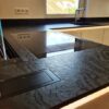 Isla de porcelánico con vitrocerámica y fregadero Dekton Liquid Embers texturedo