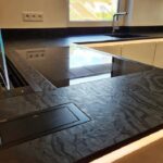 Isla de porcelánico con vitrocerámica y fregadero Dekton Liquid Embers texturedo
