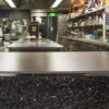 Isla y encimera de porcelánico en un restaurant Dekton Galema