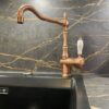 Foto de grifo y fregadero dorado en una encimera Dekton Laurent