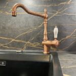 Foto de grifo y fregadero dorado en una encimera Dekton Laurent