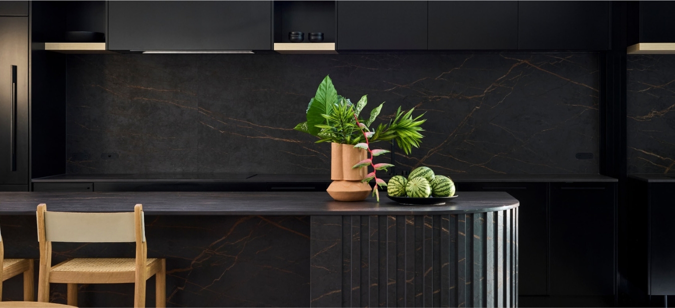 Vista de una barra de bar y restaurante con Dekton Laurent (negro con vetas doradas, resistente a impactos; alternativa Dekton Onirika para exteriores higienica con bajo mantenimiento para entornos de alto tráfico.