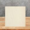 Muestra cuadrada de Neolith Arena en beige suave sobre mesa de madera, con textura sutil visible.