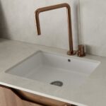 Dekton Argentium Foto de grifo y fregadero dorado en una encimera