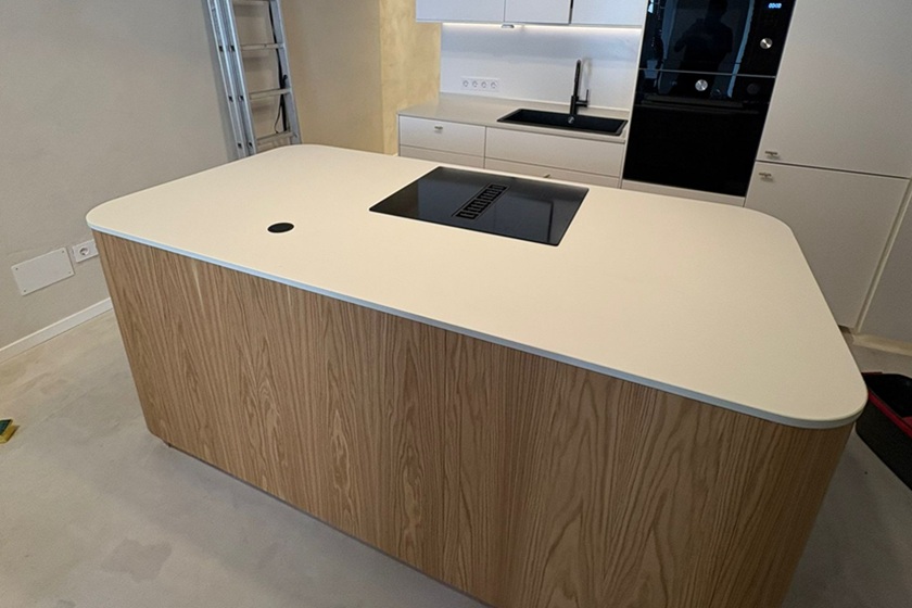 Isla de cocina con encimera de 2 cm de grosor en porcelánico blanco en proyecto moderno