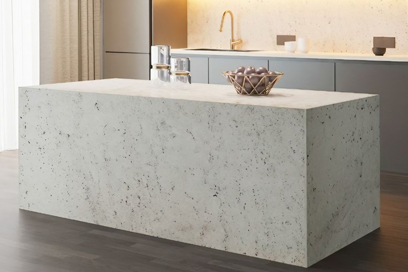 Encimera de granito blanco Naturamia Warwick Rubí en cocina minimalista de Málaga, con textura grisácea y toques rojos vibrantes, resistente y versátil para cocinas grises o blancas.