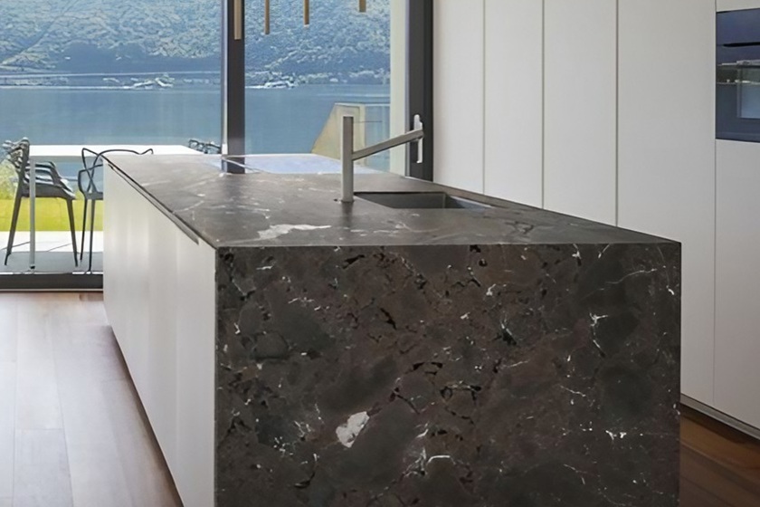 Encimera de granito marrón Naturamia Amarula en cocina moderna con vista panorámica, acabado vintage cálido y terroso, resistente y premium para reformas en Málaga.