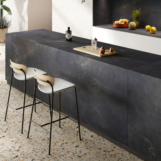 una cocina blanco con isla encimera Sapienstone Black Diamond y cascada
