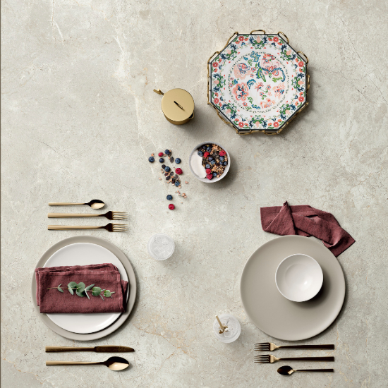 un tope de mesa Sapienstone Platinum White con cubiertos y platos