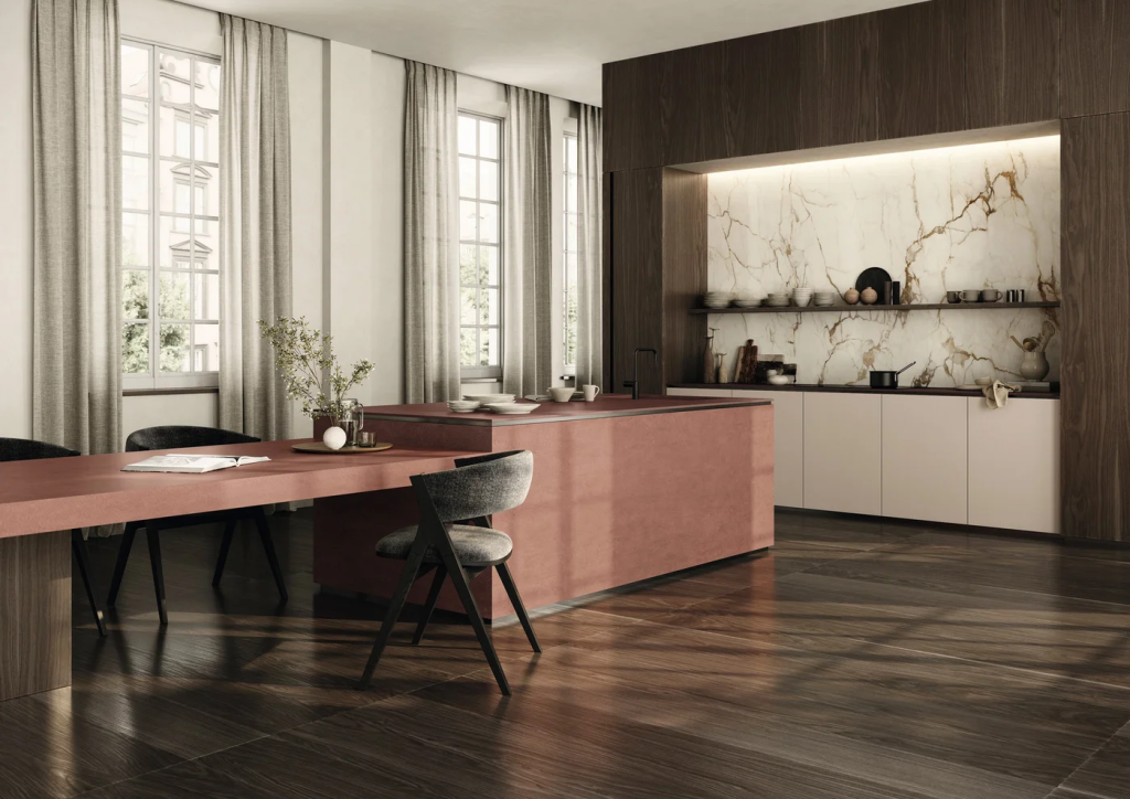 Encimera Sapienstone Balance Marsala Red en comedor moderno con isla rosa y estanterías iluminadas de mármol, vista amplia de interior lujoso