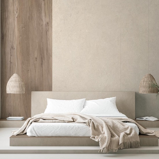 Dormitorio minimalista con pared Arklam Bateig Verona beige, cama blanca, lámparas tejidas y manta beige en ambiente sereno.