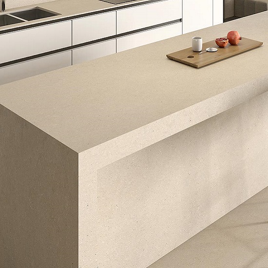 Isla de cocina Arklam Bateig Verona beige con tabla de fruta, gabinetes blancos y elementos minimalistas.
