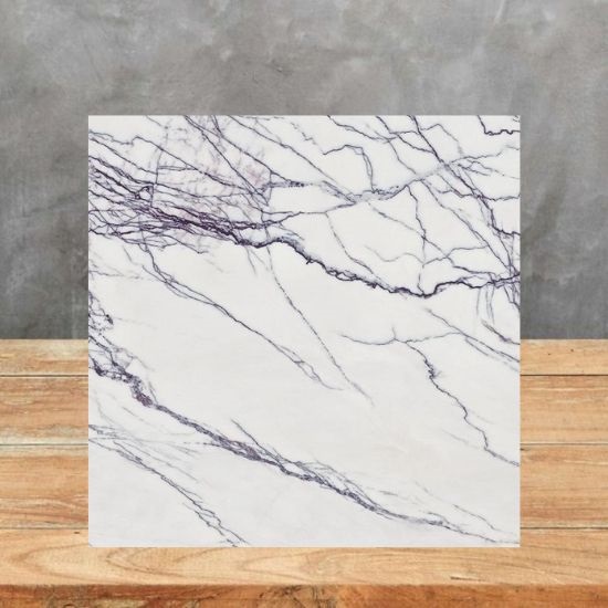 Muestra cuadrada de Arklam Lilac blanca con vetas lilas sobre mesa de madera, textura marmórea visible.