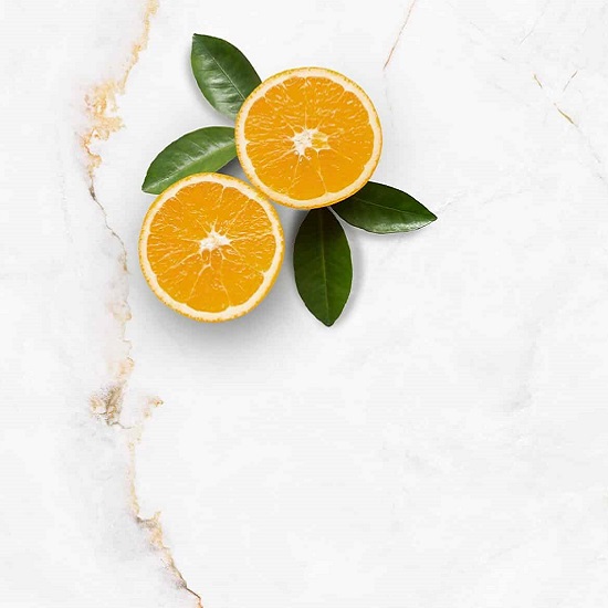 Encimera Arklam Syrac con naranjas cortadas y hojas, superficie resistente a manchas para cocinas en Málaga