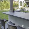 Encimera Neolith Basalt Grey en bar al aire libre Estepona, superficie gris duradera con grifo.
