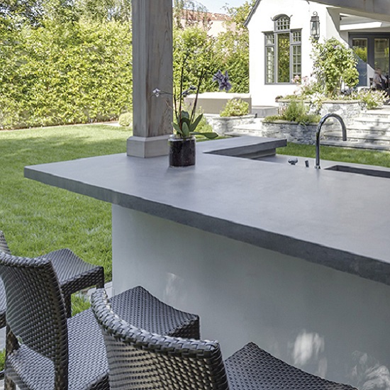Encimera Neolith Basalt Grey en bar al aire libre Estepona, superficie gris duradera con grifo.