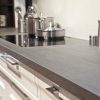 Encimera Neolith Basalt Grey en cocina Málaga, superficie gris con inducción y ollas.