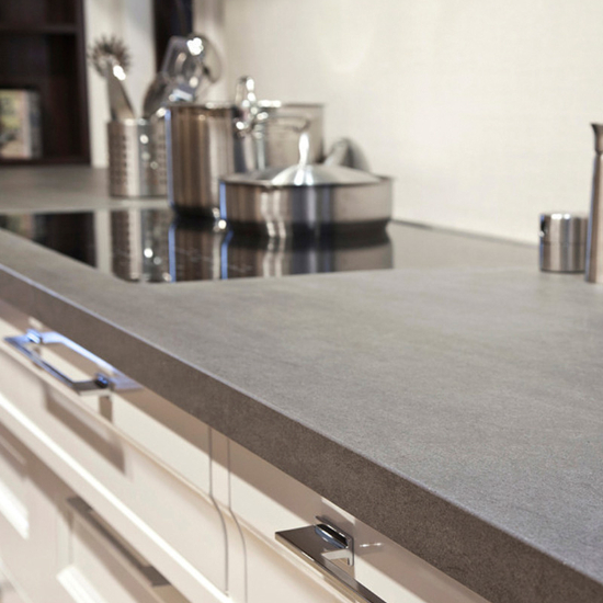 Encimera Neolith Basalt Grey en cocina Málaga, superficie gris con inducción y ollas.