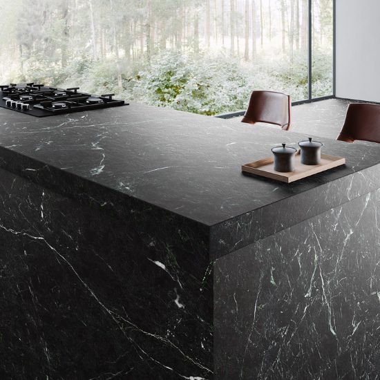 : Isla de cocina con encimera Arklam Caviar Green en Málaga, equipada con fogones y accesorios modernos.