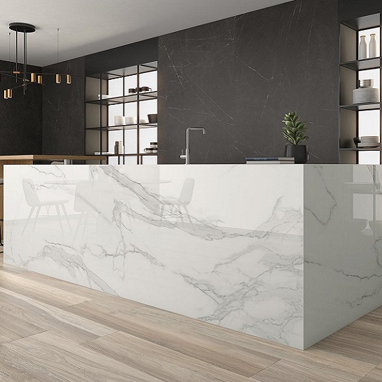 Isla de cocina moderna con encimera Arklam Estatuario en Málaga, diseño elegante con iluminación colgante.