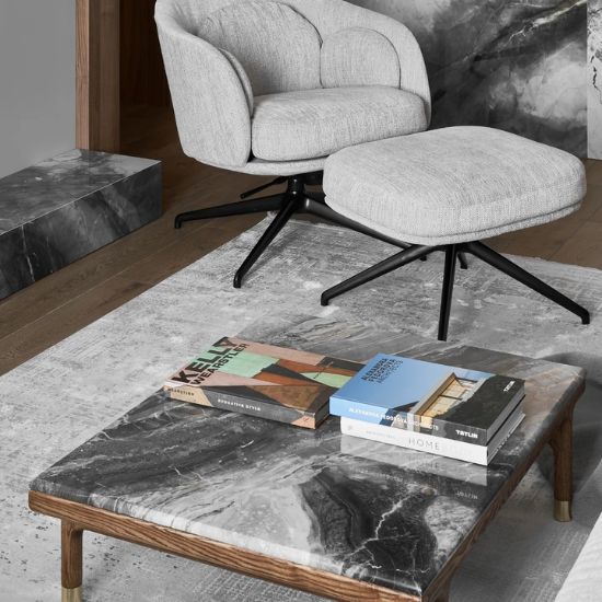 Mesa de centro Arklam Invisible Grey gris veteada con libros y alfombra en sala moderna.