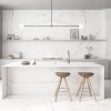 Isla de cocina moderna con encimera Arklam Melbourne en Málaga, diseño minimalista con iluminación.