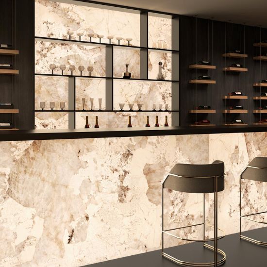 Bar moderno con revestimientos retroiluminados Arklam Patagonia Gold en Málaga, botellas y mobiliario negro.