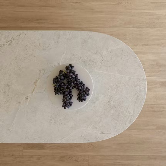 Vista aérea de encimera Dekton Evok con plato de uvas moradas sobre superficie gris ceniza con vetas sutiles.