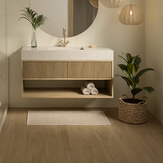 Mueble flotante de baño con encimera blanca, espejo redondo, plantas y suelo Dekton Kedar en roble.