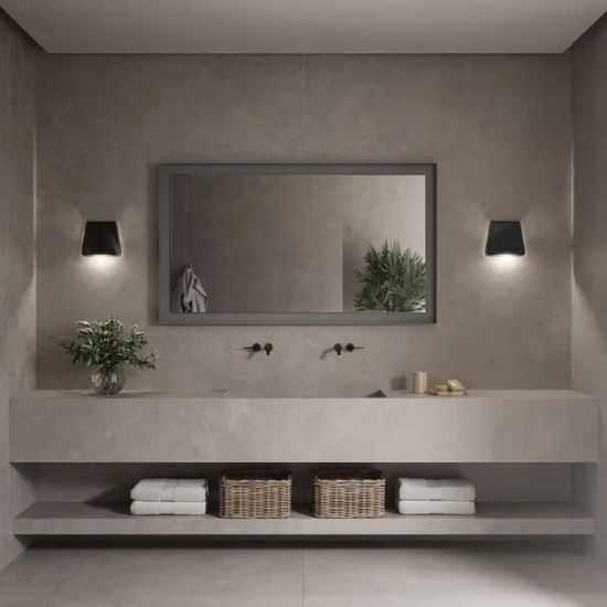 Baño moderno con vanitorio Neolith Artisan gris, espejo rectangular, luces negras y toallas en cestas.