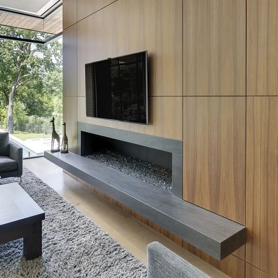 imenea flotante en Neolith Aspen Grey gris con TV, pared madera y alfombra en sala moderna.