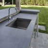 Primer plano de fregadero en encimera Neolith Aspen Grey gris con grifo y gabinetes en jardín.