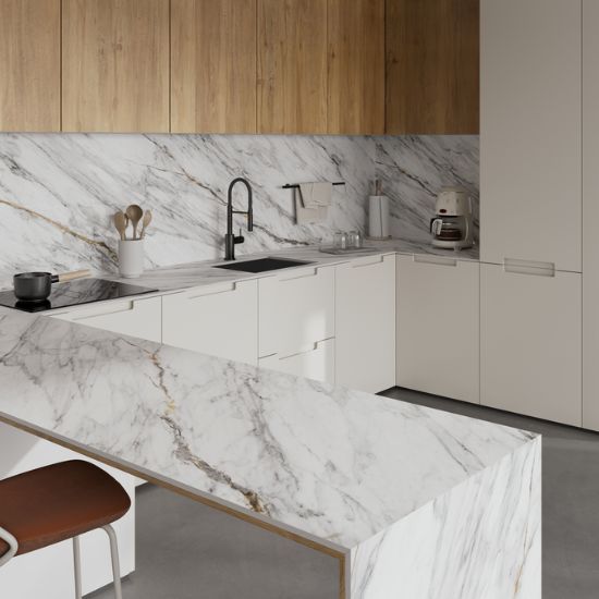 Cocina con encimera Neolith Azure blanca, gabinetes blancos, grifo negro y electrodomésticos integrados.