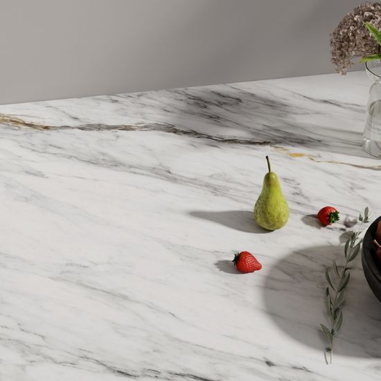 Vista cercana de encimera Neolith Azure blanca con vetas grises y doradas, pera verde, fresas y bol de fruta.