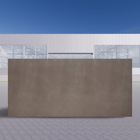 Losa grande de Neolith Barro terracota en entorno industrial al aire libre bajo cielo azul.