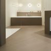 Baño con suelo y vanitorio Neolith Barro terracota, bañera, espejo y luces en diseño moderno.