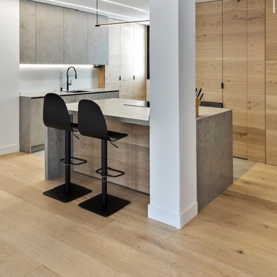 Encimera Neolith Beton en cocina gris Málaga, con inducción y accesorios de madera.