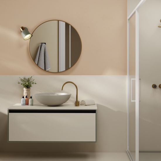 año moderno con encimera Neolith Creme, lavabo blanco, grifo dorado y espejo redondo, resistente al agua para hogares en Málaga
