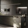 Isla de cocina con encimera Neolith Ignea, electrodomésticos integrados y frutas, ideal para espacios modernos en Málaga