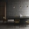 Mesa de comedor con superficie Neolith Ignea, sillas tejidas y luces colgantes, resistente para hogares en Málaga