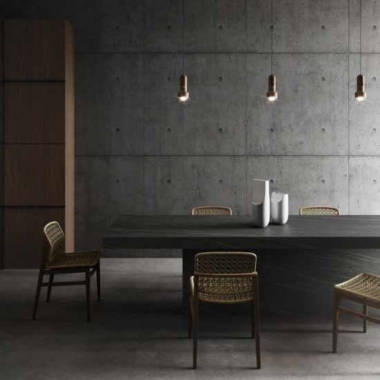 Mesa de comedor con superficie Neolith Ignea, sillas tejidas y luces colgantes, resistente para hogares en Málaga