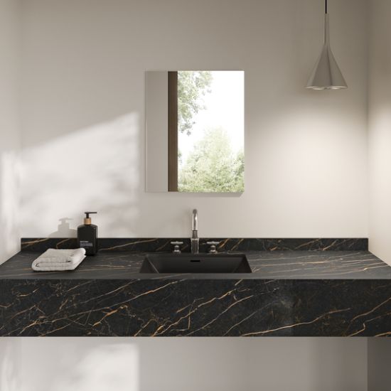 Encimera Neolith Mamba en baño minimalista Málaga, diseño negro con vetas doradas y lavabo integrado.