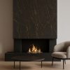Revestimiento Neolith Mamba en chimenea Málaga, diseño negro con vetas doradas y fuego.