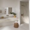 Encimera Neolith Taj Mahal en baño moderno Málaga, diseño beige con vetas ocre y ducha integrada.