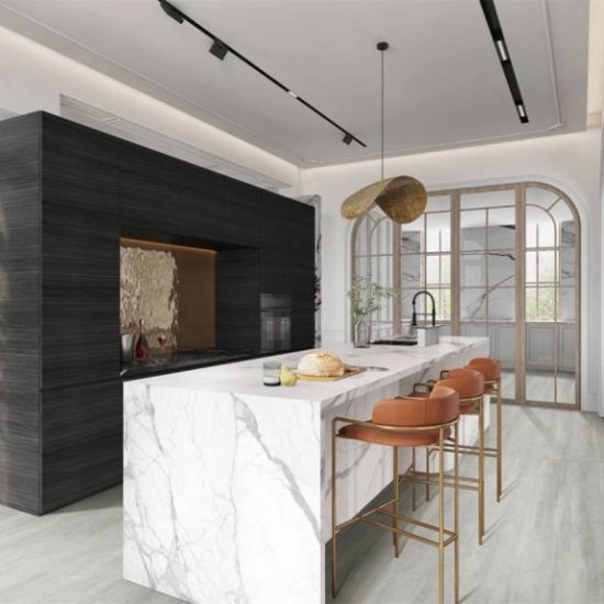 Cocina moderna con isla Blaker Statuario Bernini blanca veteada, pan, sillas naranjas y gabinetes oscuros en ambiente elegante.