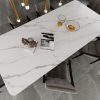 Mesa de comedor Blaker Venatino Grey blanca veteada con sillas marrones, fruta y copa en sala elegante.