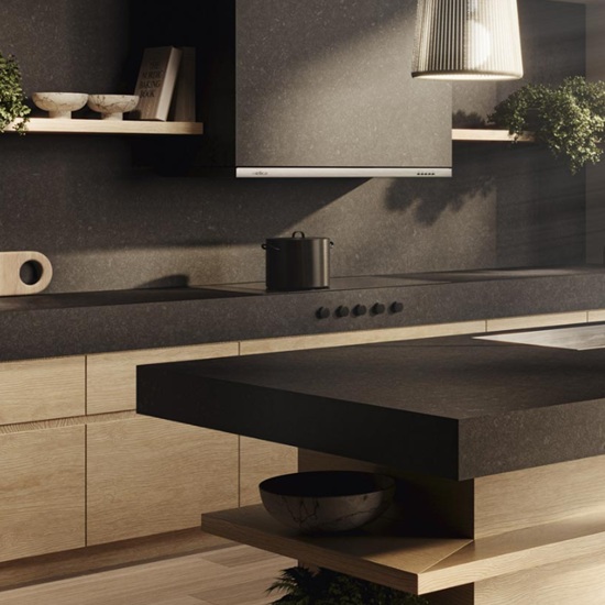 Vista cercana de isla Venux Black Zimbabwe negra uniforme con olla, estantes y plantas en cocina moderna.