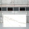 Losa grande de Blaker Calacatta Sun 320x160 cm blanca veteada en almacén industrial.