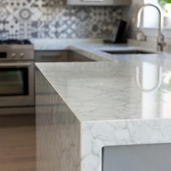 cimera de mármol Arctic White con vetas grises en cocina moderna, ideal para salpicaderos y revestimientos.