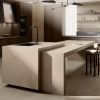 Cocina moderna con isla Venux Bellissima Beige beige veteado, taburetes madera y gabinetes oscuros en ambiente elegante.